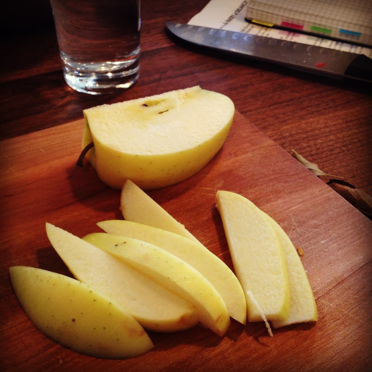 Fresh apple cut into slices on a wooden chopping board